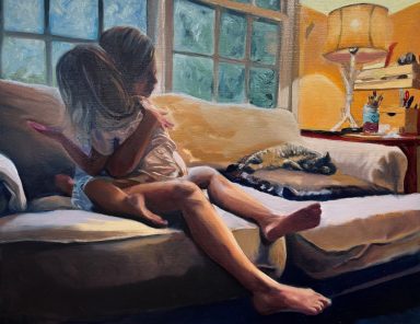 Two children play together on a sofa in a warmly lit room.